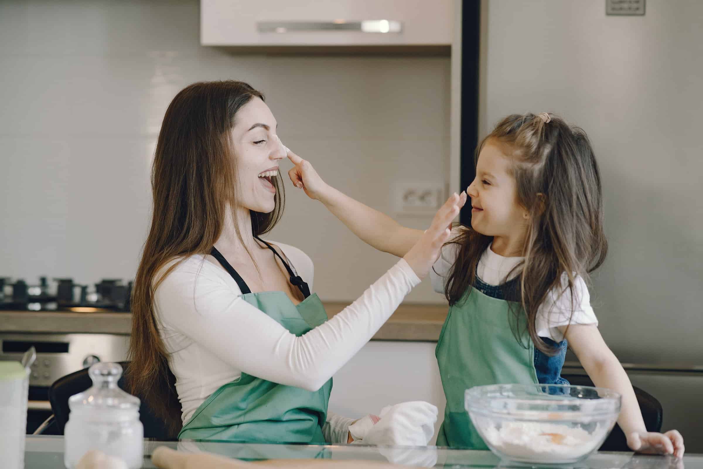 female babysitter baking with child