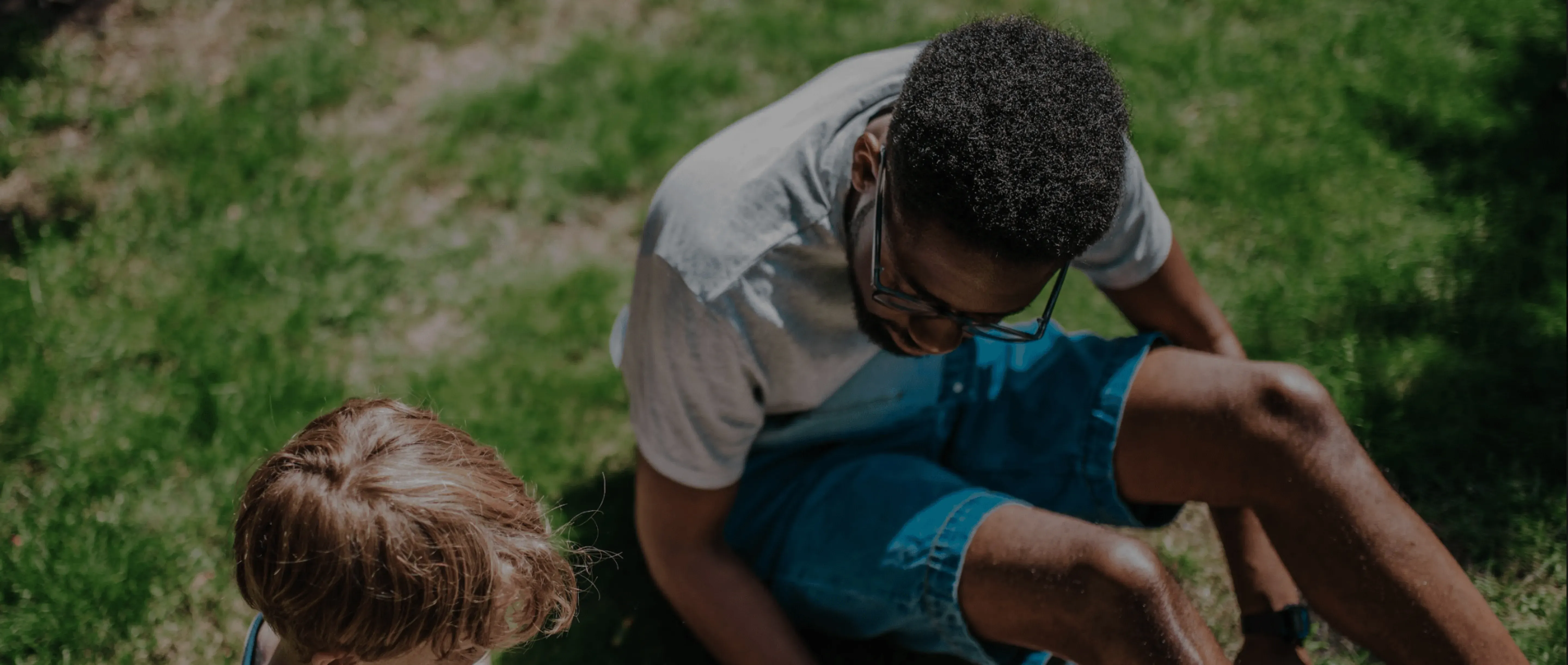 Sitter on lawn with child