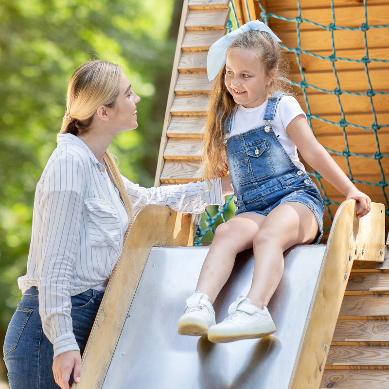 Girl on slide with babysitter at the weekend